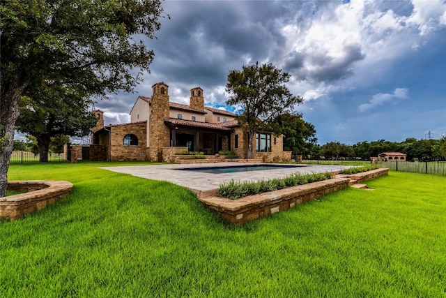 rear view of house with a yard and a patio area