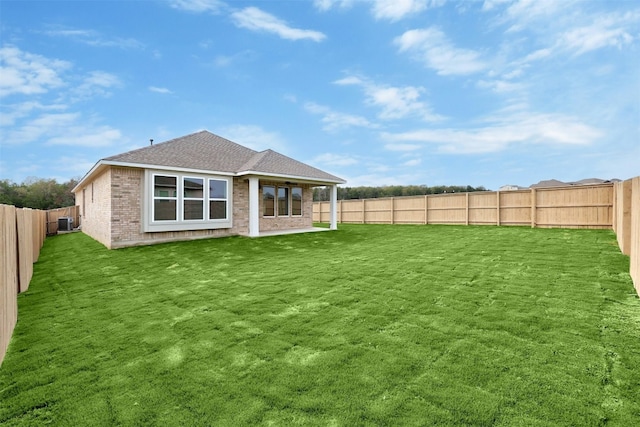 rear view of property with central air condition unit and a lawn