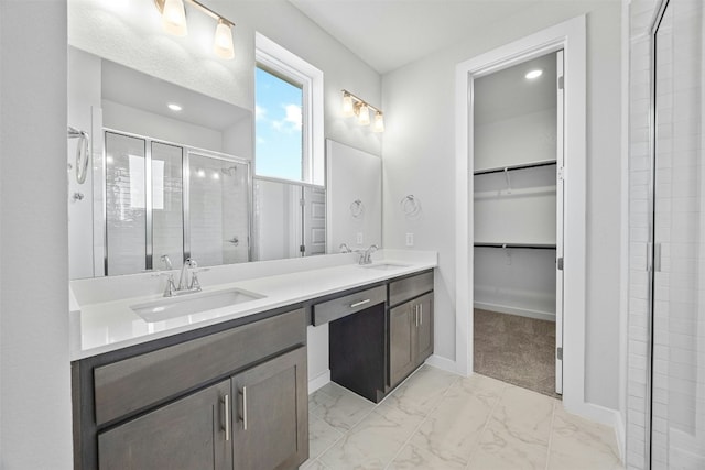 bathroom featuring a shower with door and vanity