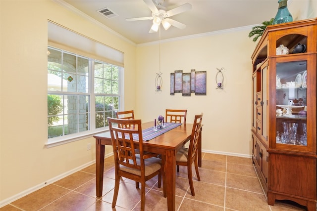 tiled dining room featuring ceiling fan and crown molding