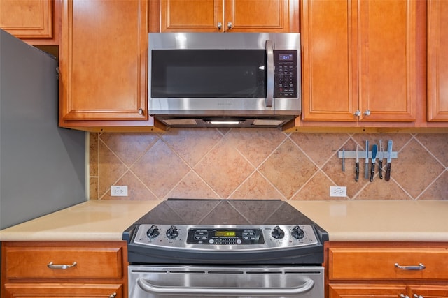 kitchen with appliances with stainless steel finishes and backsplash