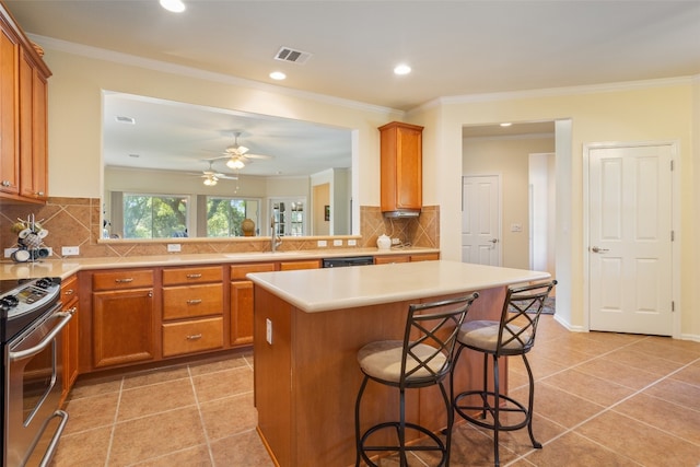 kitchen with decorative backsplash, a center island, light tile patterned floors, and a breakfast bar