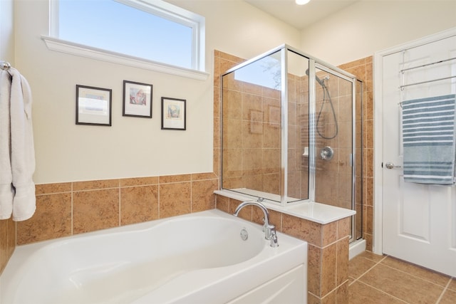 bathroom with tile patterned flooring and shower with separate bathtub