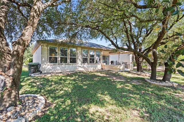 rear view of house featuring a yard