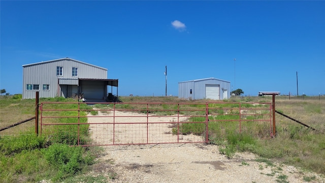 view of yard with an outdoor structure, a garage, and a rural view