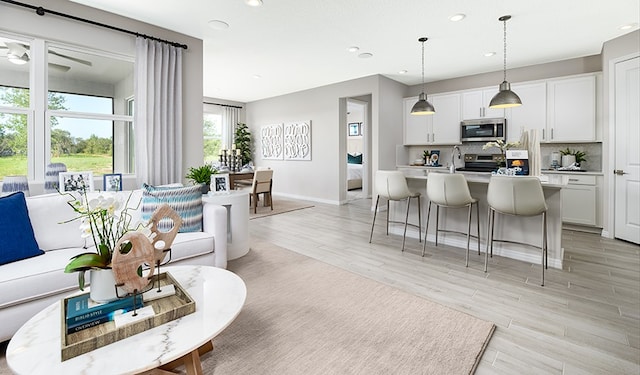 living room featuring ceiling fan and light hardwood / wood-style flooring