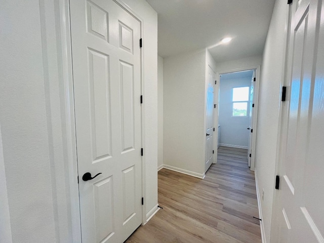 corridor with light hardwood / wood-style floors