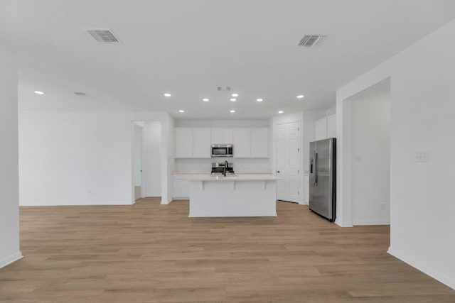 1004 Stonehill Dr, Georgetown, TX 78633 - kitchen with stainless steel appliances, open floor plan, recessed lighting, a kitchen bar, and light countertops
