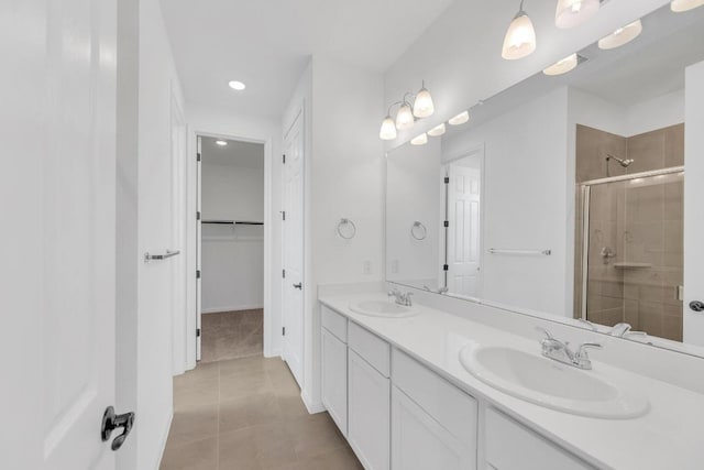 1004 Stonehill Dr, Georgetown, TX 78633 - bathroom featuring a stall shower, recessed lighting, double vanity, tile patterned floors, and a spacious closet