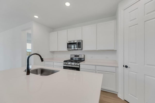 1004 Stonehill Dr, Georgetown, TX 78633 - kitchen featuring stainless steel appliances, a sink, white cabinets, recessed lighting, and light countertops
