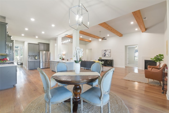 dining space featuring beamed ceiling, plenty of natural light, and light hardwood / wood-style floors