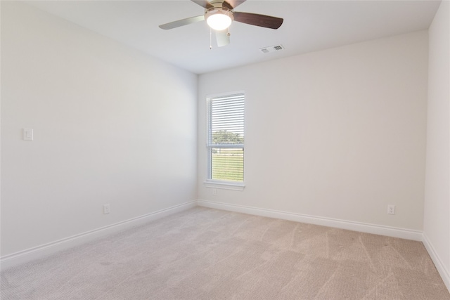 spare room featuring ceiling fan and light carpet