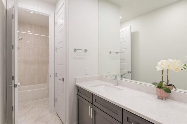 bathroom featuring tiled shower / bath combo and vanity