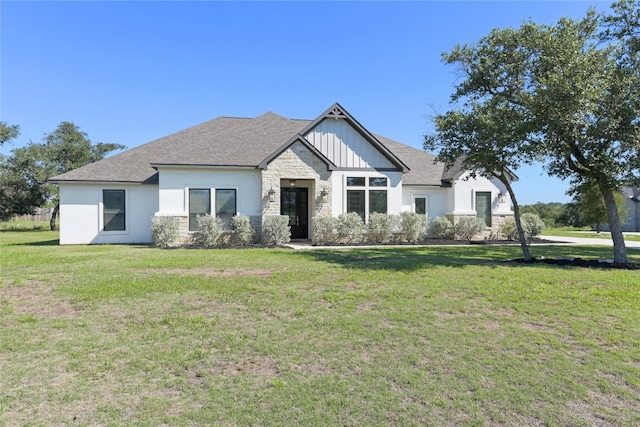 view of front of property featuring stone siding, a front lawn, and a shingled roof