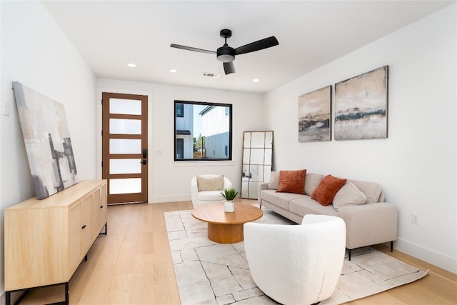 living room with ceiling fan and light hardwood / wood-style flooring