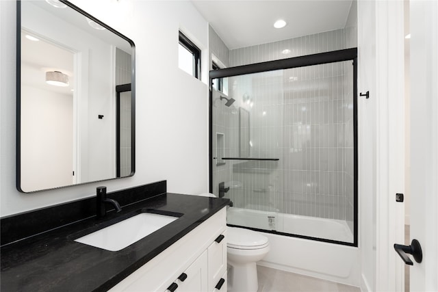 full bathroom featuring vanity, toilet, and combined bath / shower with glass door