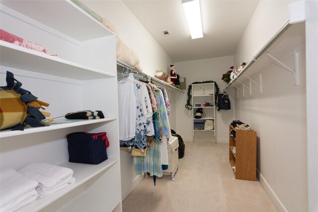 walk in closet with light colored carpet