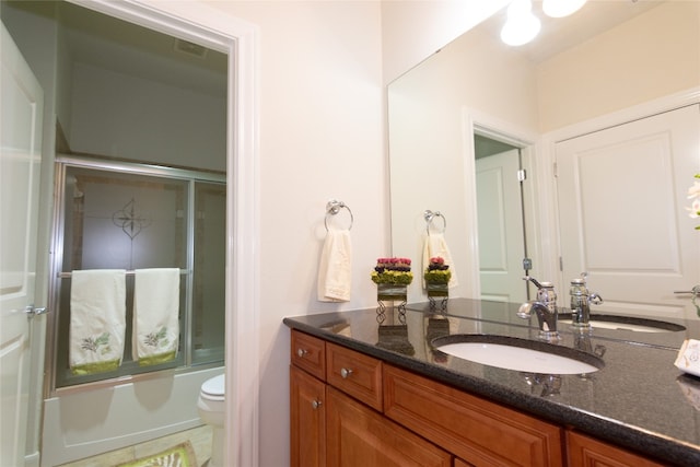 full bathroom featuring combined bath / shower with glass door, vanity, and toilet