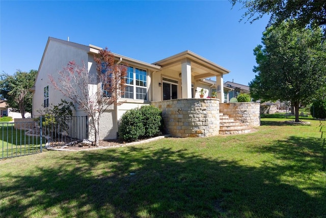 view of property exterior with a yard, fence, and stucco siding