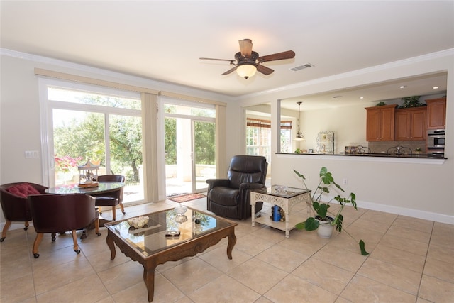 living room featuring a wealth of natural light, crown molding, and light tile patterned flooring