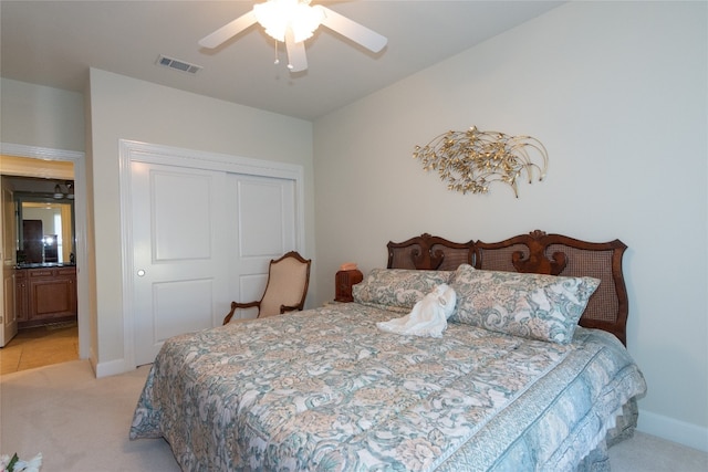 bedroom with ceiling fan, a closet, and light carpet