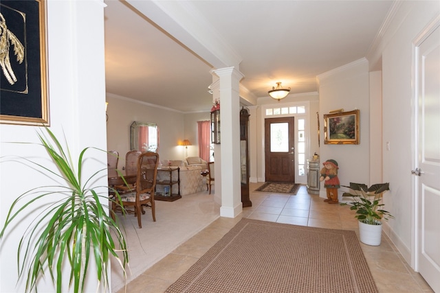 entrance foyer featuring decorative columns, crown molding, and light tile patterned floors