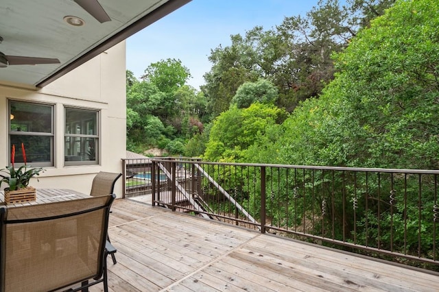 wooden deck featuring a ceiling fan, outdoor dining area, and an outdoor pool