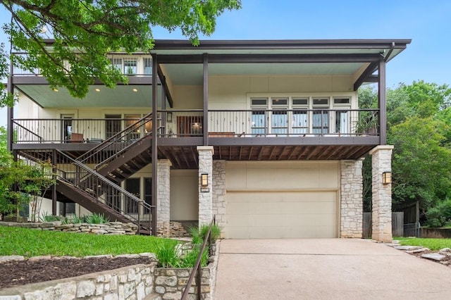 view of front of property with a garage, driveway, and stairway