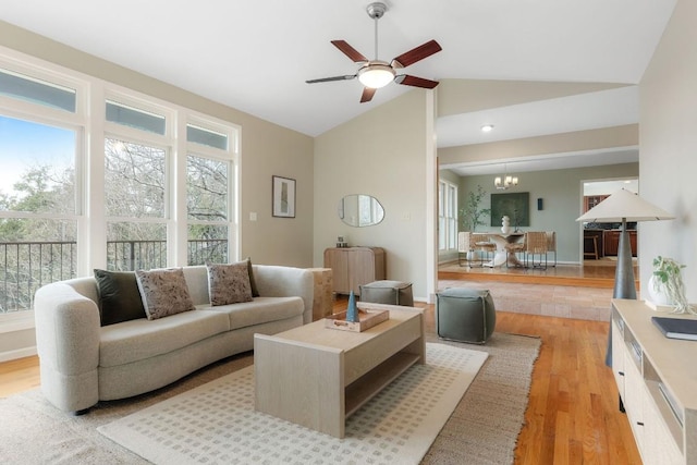 living room featuring lofted ceiling, light wood-style flooring, ceiling fan with notable chandelier, baseboards, and radiator heating unit