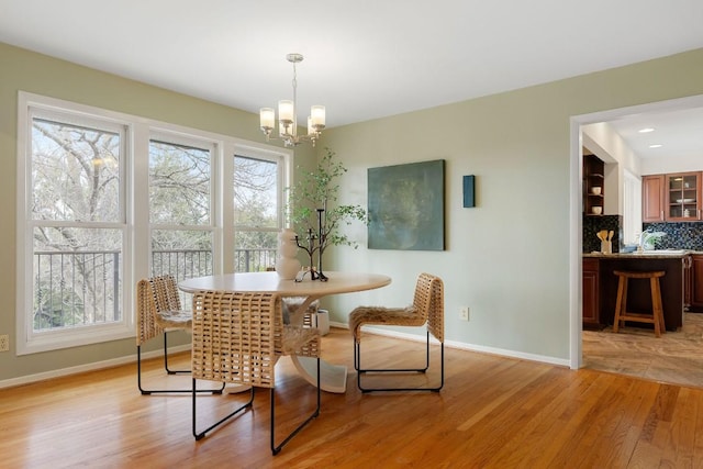 dining space featuring light wood-style flooring, a wealth of natural light, and baseboards