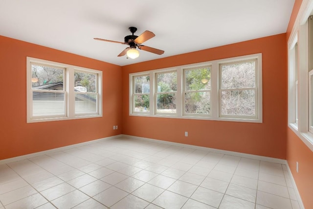 spare room featuring light tile patterned floors, baseboards, and a ceiling fan