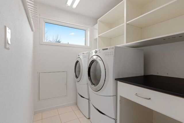 clothes washing area with light tile patterned floors, laundry area, and washing machine and clothes dryer