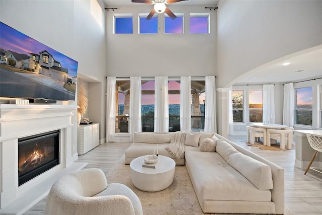 living room with a towering ceiling and ceiling fan