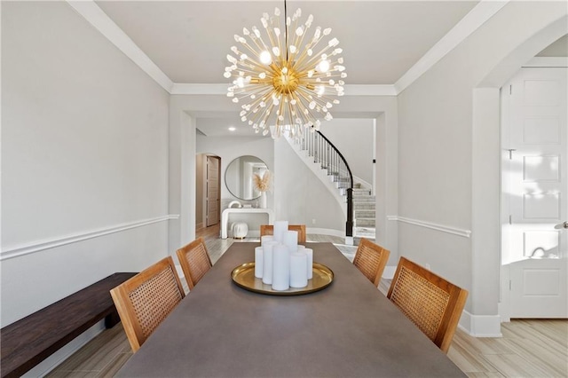 dining space featuring ornamental molding, light wood-type flooring, and an inviting chandelier