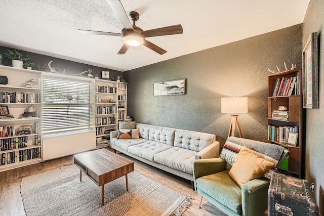 living room featuring a textured ceiling, ceiling fan, and hardwood / wood-style flooring