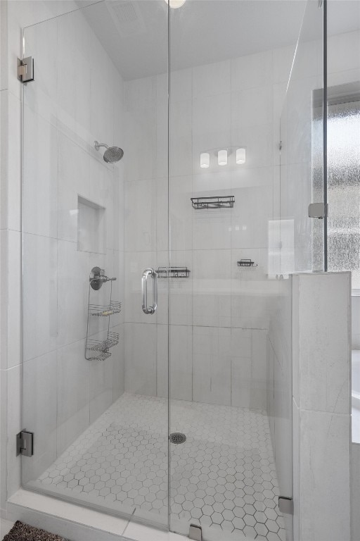 bathroom featuring a shower with shower door