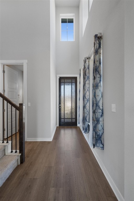 entrance foyer featuring a towering ceiling and dark hardwood / wood-style flooring