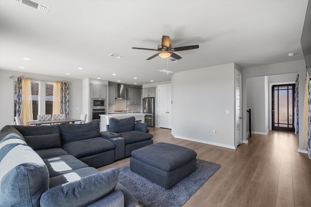 living room featuring ceiling fan, hardwood / wood-style flooring, and sink