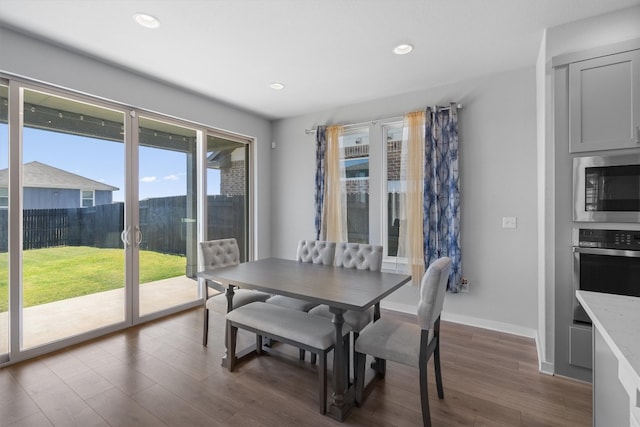 dining space with dark wood-type flooring and a wealth of natural light