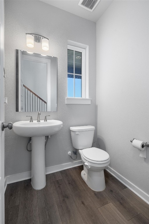 bathroom with hardwood / wood-style floors and toilet