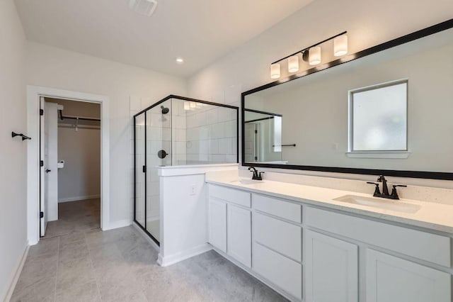 full bathroom featuring a spacious closet, a stall shower, and a sink