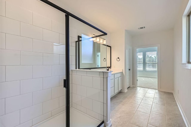 full bath with visible vents, a stall shower, vanity, baseboards, and tile patterned floors