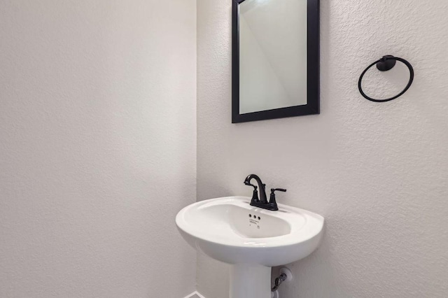 bathroom with a textured wall and a sink