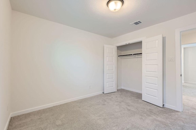 unfurnished bedroom with a closet, carpet flooring, visible vents, and baseboards