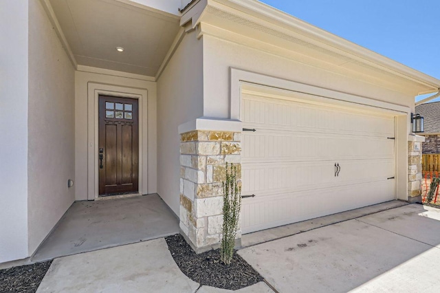 property entrance with stucco siding and a garage