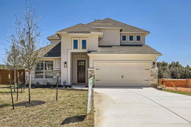 prairie-style home with fence, roof with shingles, stucco siding, driveway, and an attached garage