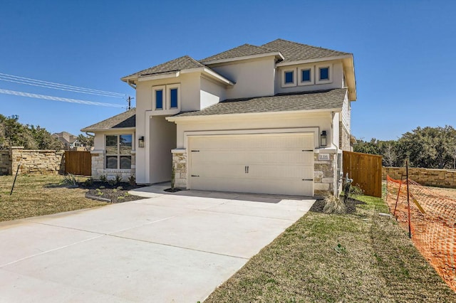 prairie-style house featuring fence, stone siding, and stucco siding