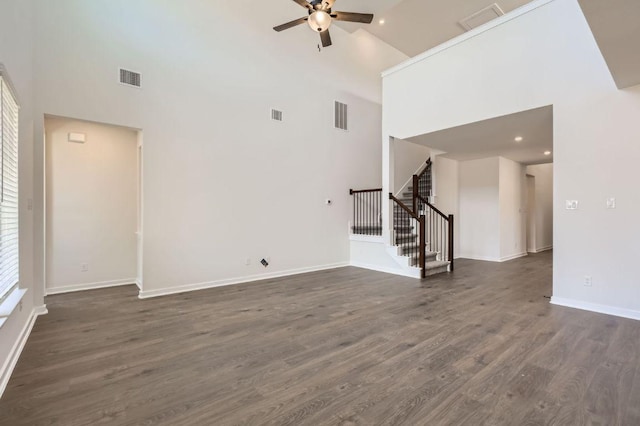 unfurnished living room with dark wood-style floors, stairway, a ceiling fan, and visible vents