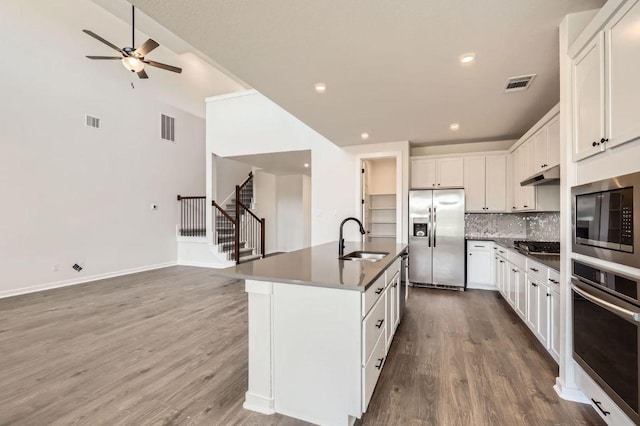 kitchen with dark countertops, visible vents, stainless steel appliances, and a sink