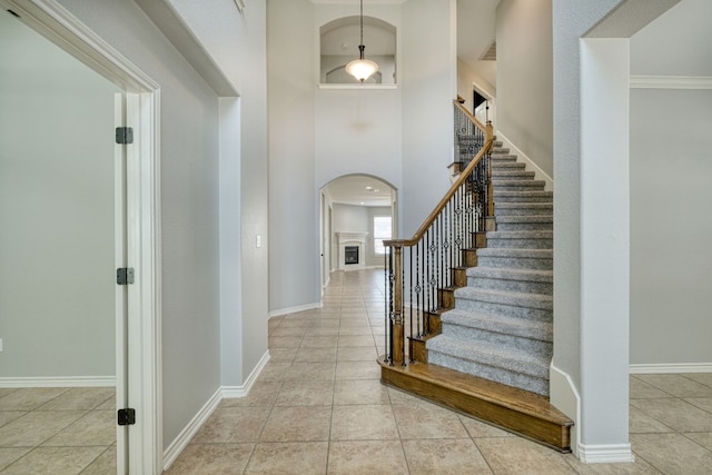 tiled entrance foyer featuring a high ceiling and crown molding